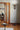 Oluce Pascal floor lamp in a wood-paneled room with a round table and an open doorway