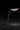 Oluce Plume table lamp by Christophe Pillet glowing against a dark background