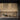 ET2 Penrose gold open-cornered cube pendants hanging in front of wood kitchen cabinets