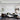 ET2 Pipette glass tube pendants in a cluster over a living room with a black sofa and marble coffee table