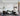 ET2 Pipette glass tube pendants in a cluster over a living room with a black sofa and marble coffee table