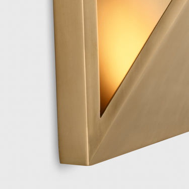 The Punto 10 in brass, used as a stylish and functional bedside lamp in a minimalist bedroom.