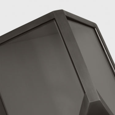 A close-up of the Punto 10 wall sconce in bronze, showing the integrated LED light glowing softly from behind the clear glass panes.