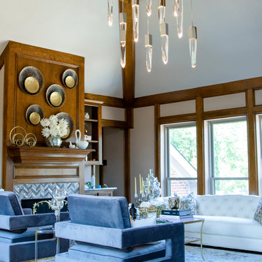 ET2 Quartz crystal stalactites hung at varied heights from a high wood-coffered ceiling above blue velvet chairs