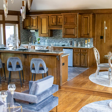 ET2 Quartz crystal pendants in an open kitchen and living area with wood cabinets and blue counter stools