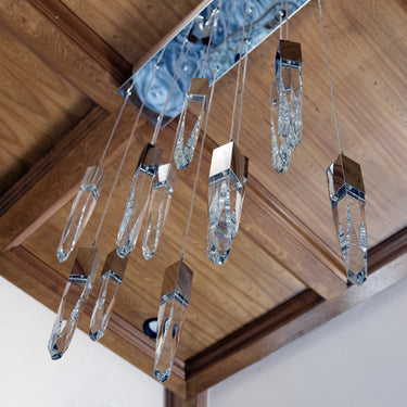 Looking up at ET2 Quartz crystals hung from a chrome canopy under a wood-coffered ceiling