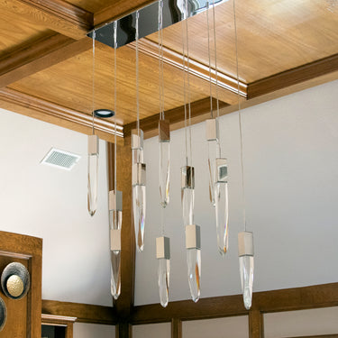 ET2 Quartz crystal cluster at different lengths under a wood-coffered ceiling in a room with round brass wall plaques