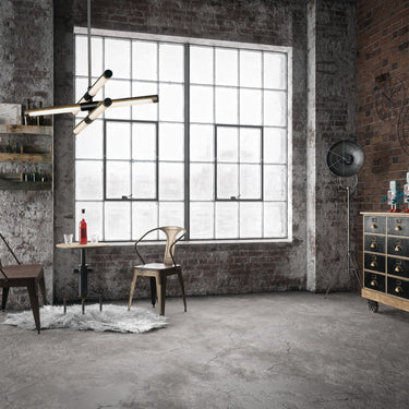 ET2 Rollo tube pendant hung in an industrial loft with a brick wall, tall windows and a small bistro table