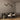 Trace Linear chandelier with crossing bronze strands and glass tips above a long dark oval dining table with cream chairs