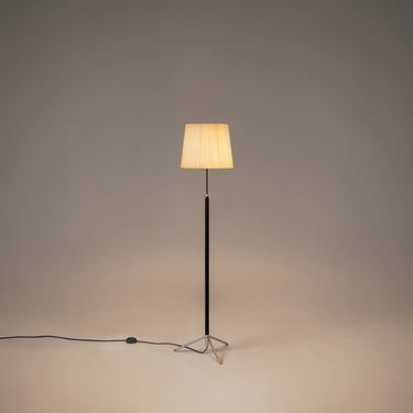 Santa & Cole Pie de Salón G3 floor lamp with Natural Ribbon shade and chrome finish beside a modern lounge chair