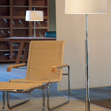 Santa & Cole Diana floor lamp beside a modern reading chair