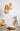 Lit Drop pendant glowing beside a chair in a styled room, Graypants Scraplights lifestyle photograph
