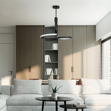 ET2 Serpentine looping black and white semi-flush mount hung over a coffee table and gray sofa in a living room with wood cabinets