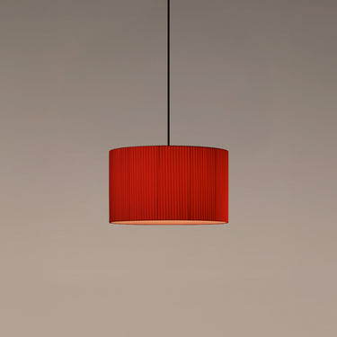 Santa & Cole Sísísí Cilíndricas hanging light with warm illumination and elegant red ribbon shade