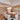 ET2 Spiral rectangular crystal bead pendant over a dining table in an open-plan room with a staircase and sitting area behind