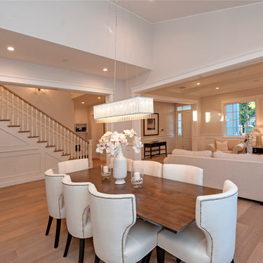 ET2 Spiral rectangular crystal bead pendant over a dining table in an open-plan room with a staircase and sitting area behind