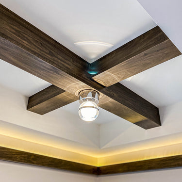 ET2 Swank small clear orb with a chrome band on a ceiling where two dark wood beams cross