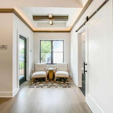 ET2 Swank orb on the ceiling beam of a coffered hallway above a sitting nook with two chairs