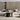ET2 Syndicate tall clear hourglass glass pendant with black bands beside a beige sectional sofa in a living room