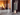 Conmoto Teras Fireplace Tools with Stand, next to an open fire