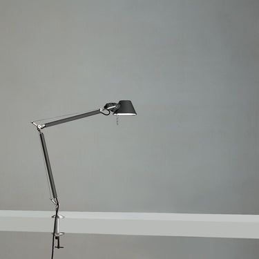 Black Tolomeo Mini task lamp by Artemide on wooden office desk with stylish design 