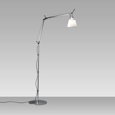 Modern adjustable floor lamp by Artemide featuring polished aluminum body and warm fabric diffuser for ambient lighting