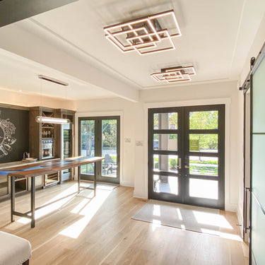 ET2 Traverse LED layered frames on a coffered entry ceiling beside a barn door, with a second fixture farther back