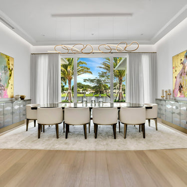 ET2 Unity looping linear pendant over a long dining table in a formal dining room with two large paintings
