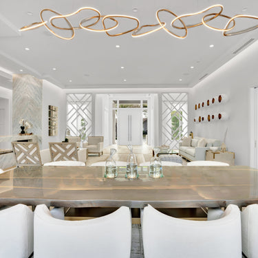 ET2 Unity looping linear pendant on a high ceiling above a dining table with white chairs