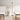 Tepa Medium floor lamp in black standing between lounge chairs in a daylit seating area