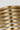 Close-up of the Quoddy Small lamp in Natural Brass, light glowing between the brass rings
