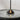 Moneta Short Accent table lamp in Black lit beside outdoor seating, three-quarter view