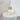 Caspe 8 lamp with its metal cap on top and a glowing crystal body on a white side table