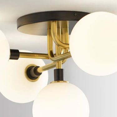 Brass flush mount ceiling fixture featuring five dimmable opal glass lights for home or hospitality settings