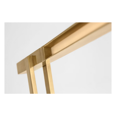 Natural brass Stagger floor lamp positioned in a hotel lobby, highlighting its sleek, architectural design.