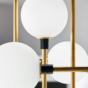 Brass chandelier with frosted opal glass globes, suited for high-end residential or professional interiors