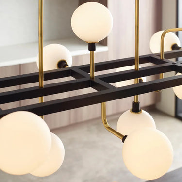 Linear suspension chandelier with opal globes and brass finish, suitable for homes and commercial settings