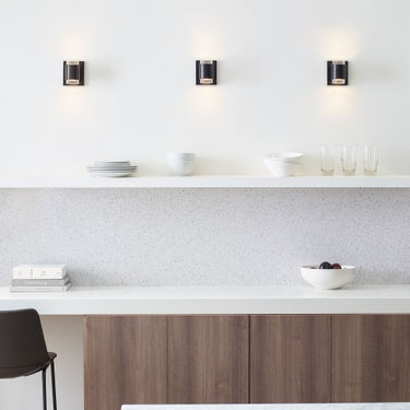 Black Voto round LED wall sconce, showcasing its use as energy-efficient hallway lighting, with a 50000-hour LED lifespan