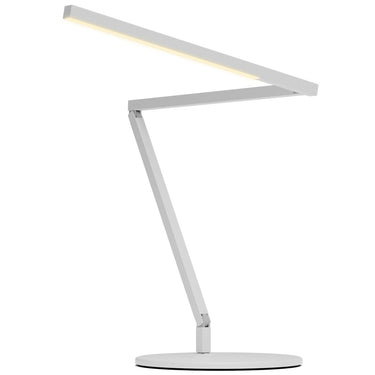 A lifestyle image of the Koncept Z-Bar lamp illuminating a modern bedroom nightstand, with its warm 3500K color temperature creating a cozy ambiance in matte white finish.