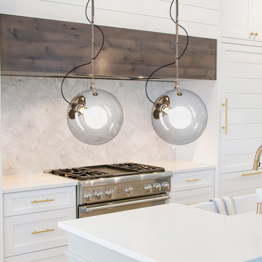 Miconos pendant light by Artemide with hand-blown glass globe installed in a kitchen island