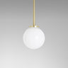 Mezzo pendant with a white opal glass ball on a satin brass rod, studio view