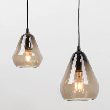 Contemporary clear glass pendant light illuminating a modern living room space.