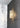 Whistler wall light glowing on a dark tiled wall beside white marble