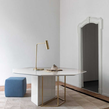 Heron table lamp with a slim stem and a cylindrical shade, in a room setting