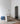 Heron table lamp with a slim stem and a cylindrical shade, in a room setting