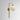 Big Bulb wall light in polished brass with a shiny opal glass globe on a curved arm, studio view