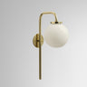 Big Bulb wall light in polished brass with a shiny opal glass globe on a curved arm, studio view
