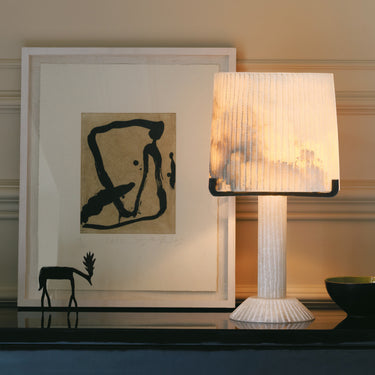 Acropolis table lamp on a console in front of framed abstract art