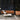 Carapace pendant hanging over a coffee table beside a tan leather sofa against a dark wall