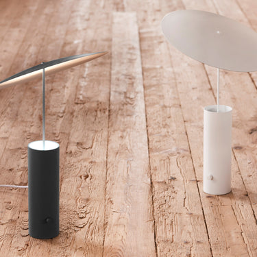 Table lamp, the black and white versions on a wood floor | Parasol by Innermost